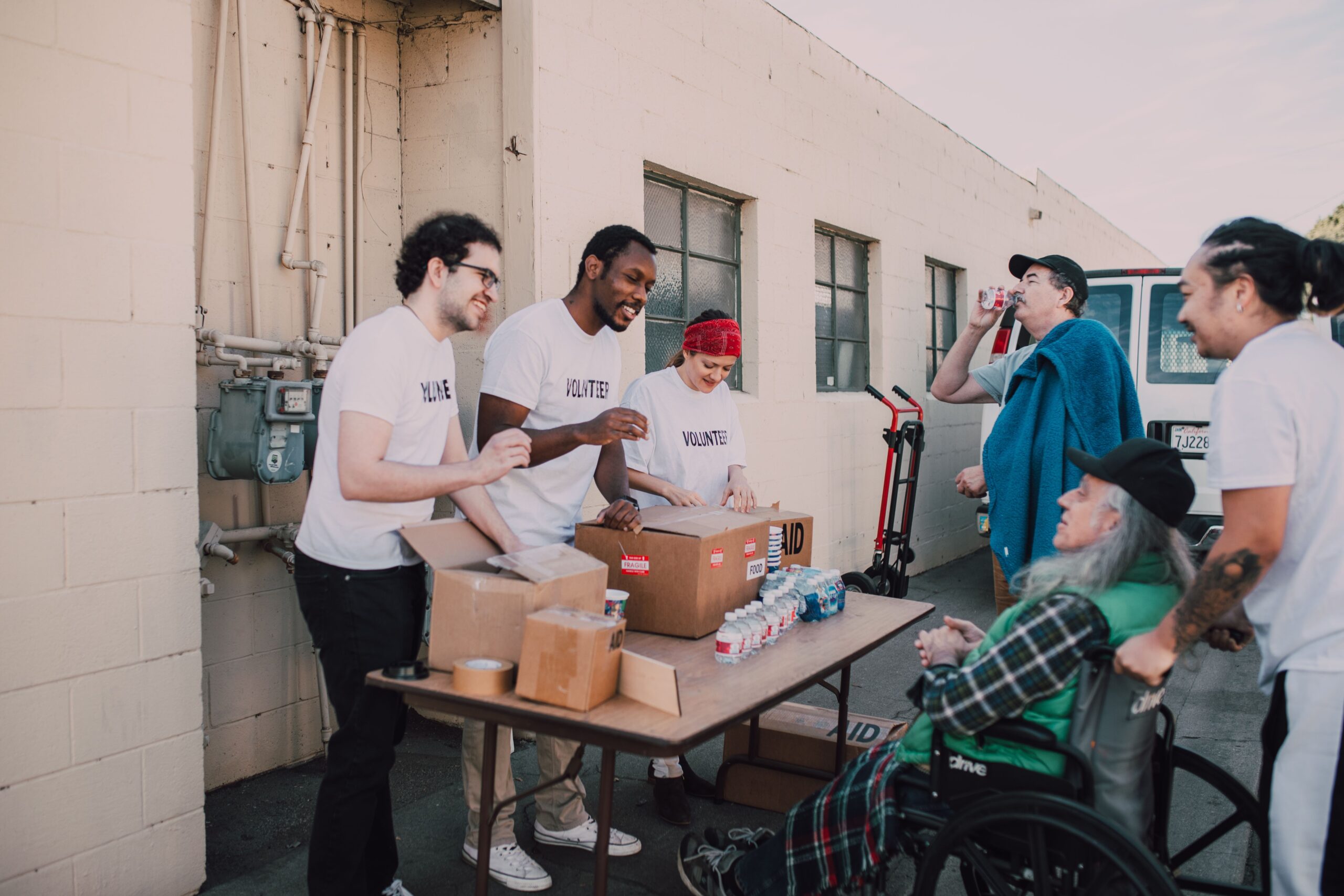 A group of diverse volunteers engaging in a community service activity outdoors, providing aid and support.